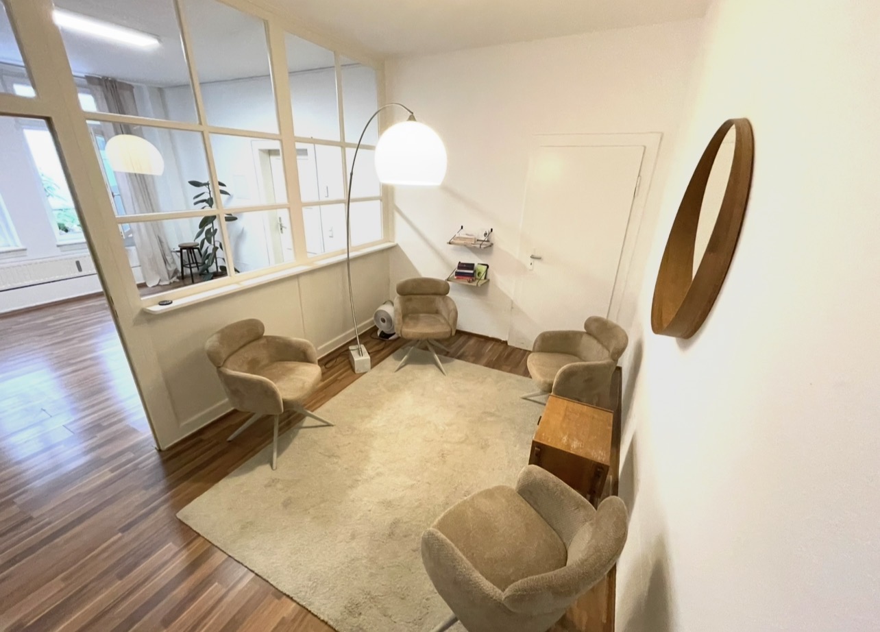 Gesprächsraum mit Sesseln und Bogenlampe im Hinterhof-Loft München